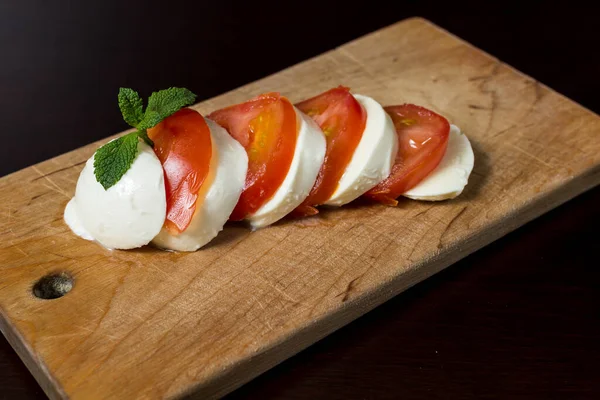 Voedselachtergrond Gesneden Mozzarella Kaas Gesneden Tomaat Een Houten Plaat Met — Stockfoto