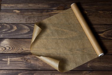 Ahşap bir masanın üzerinde bir rulo kağıt. Paketleme için kağıt.