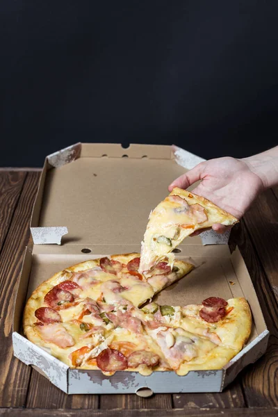 Samičí Ruka Kousek Pizzy Pizza Otevřené Lepenkové Krabici Dřevěném Stole — Stock fotografie