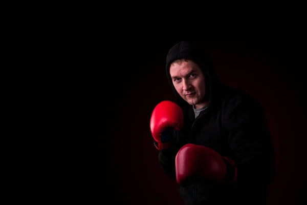Boxer Červených Rukavicích Černou Bundu Kapucí Tmavé Stěny Červeným Podsvícením — Stock fotografie