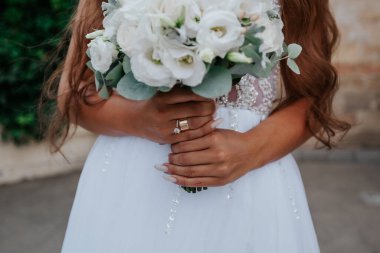 Gelin düğün buketi tutuyor, yakın plan.