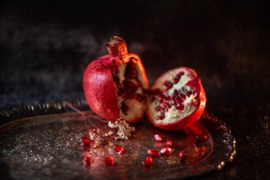 Arkaplanda güzel bir şarap tepsisinin üzerine serpiştirilmiş tahıllar serpiştirilmiş yarım nar.