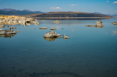 Kayalık Mono Gölü 'nün mavi gökyüzü ve mavi suyu, Kaliforniya, ABD
