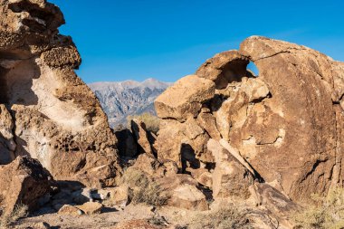 Owens Valley California 'da çöl kaya oluşumları ve uzak dağlar.
