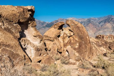 Owens Valley California 'da çöl kaya oluşumları ve uzak dağlar.