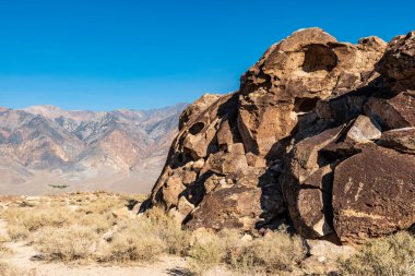 Owens Valley California 'da çöl kaya oluşumları ve uzak dağlar.