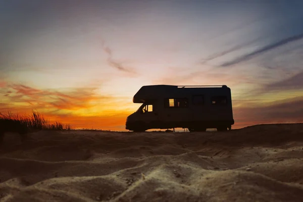 Günbatımı ve karavan siluet. Van hayat kavramı. Avrupa'da seyahat. Camper van sahilde.