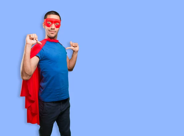 Proud superhero posing against blue background