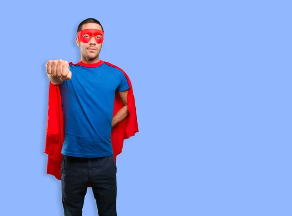 Confident superhero flying against blue background