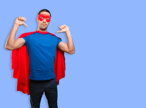 Proud superhero posing against blue background
