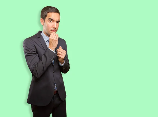 Doubtful young businessman doing a distrust gesture