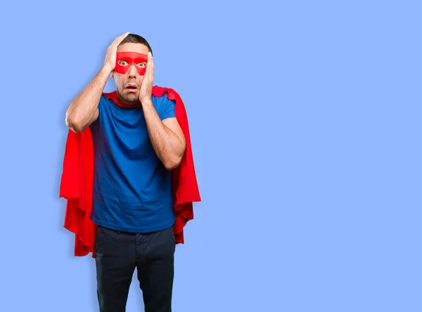 Shocked superhero posing against blue background