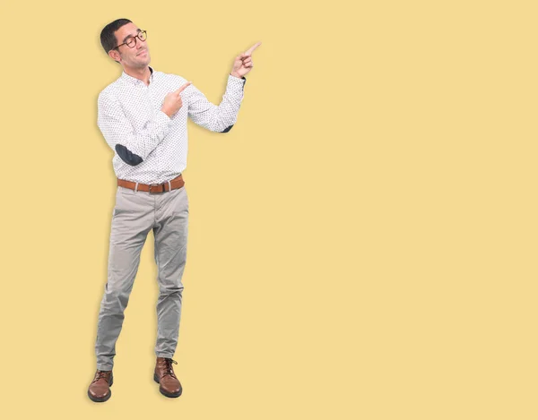 Confident young man pointing with his hand - Concept of selling with an ad - Full body shot