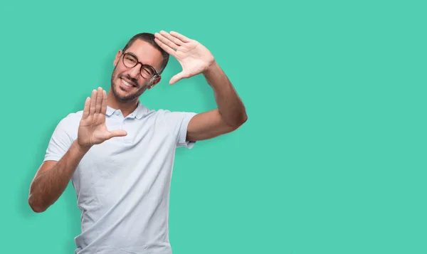 Happy young man doing a frame gesture with his hands