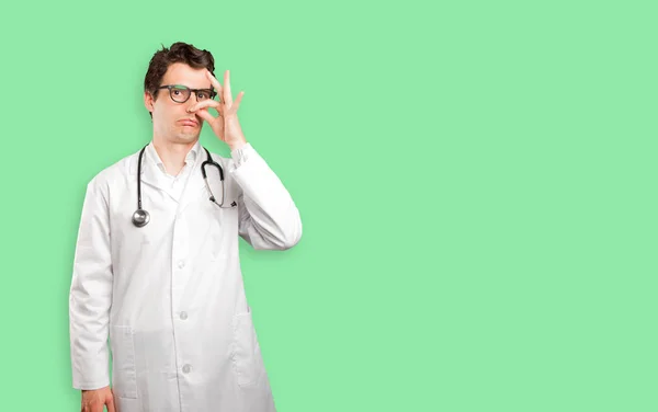 Worried doctor with bad smell gesture against white background