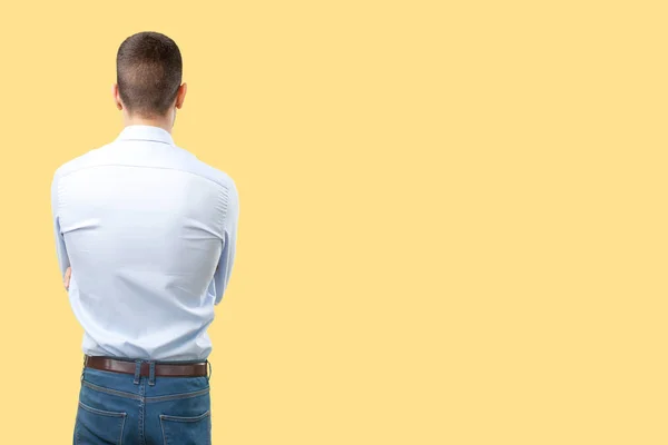 Young man back against yellow background