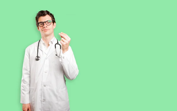 Confident doctor with money gesture against white background