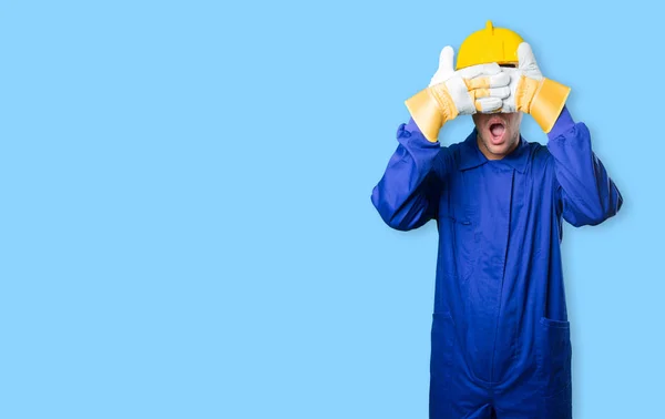 Workman covering his eyes with his hands on white background