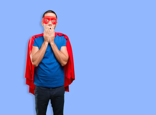 Shocked superhero posing against blue background