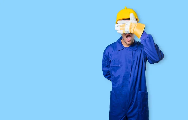 Workman covering his eyes with his hands on white background