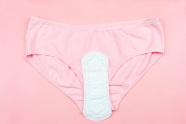 Üst görünüm beyaz hijyenik peçete ve pembe arka planda pembe altlıklar.