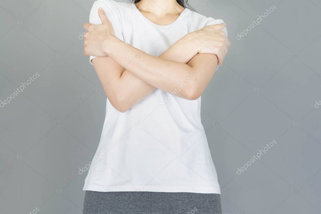 Woman hugged herself isolated on gray background