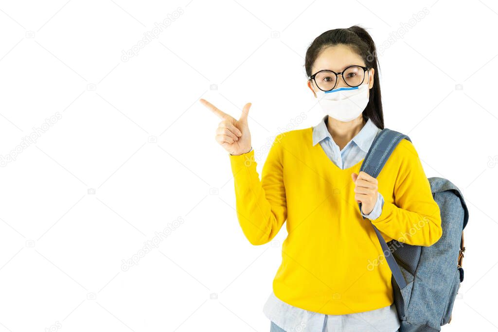 Young asian student woman in glasses wearing medical face mask,carrying a bag to go to school Under the outbreak of the virus isolated on white background