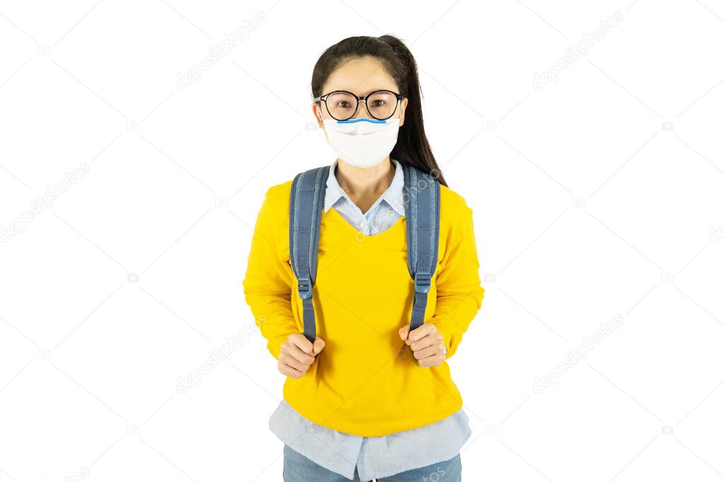 Young asian student woman in glasses wearing medical face mask,carrying a bag to go to school Under the outbreak of the virus isolated on white background