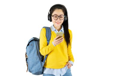 Gözlüklü, sırt çantalı, beyaz arka planda izole edilmiş cep telefonlu mutlu, sıradan bir kız öğrencinin portresi.