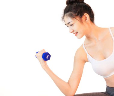 Genç ve güzel Asyalı bir kadın pembe yoga topu, portakal suyu ve mavi dambıl ve yeşil elma ağırlığını kontrol eden ince vücut bakımı ile beyaz atlet egzersizi yapıyor.