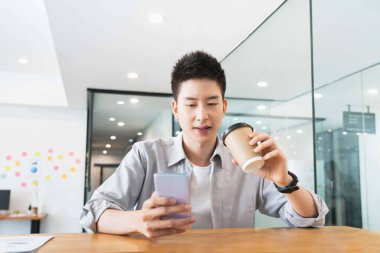 Ofiste sıradan gömlekli Asyalı genç bir iş adamı.,