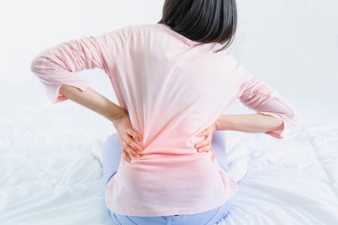 Yatak odasında sırt ağrısı olan çekici bir kadın, bu yatak düşündüğüm kadar rahat değil, bel ağrısı olan bir kadın.