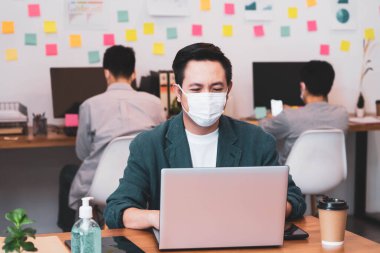 Korunma Corona gribi için koruyucu maske takan genç Asyalı işadamı, sağlık fikirleri konsepti ofisinin arka planını engelliyor..