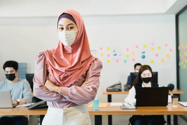 small business startup group wearing protective mask for covid19 protection corona flu prevent healty ideas concept office background.The work with new normal lifestyle in office.focus on muslim woman