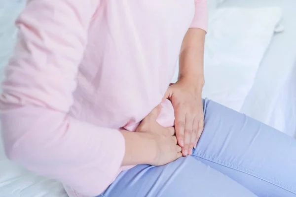 Jinekoloji konsepti. Adet sancısı, hazımsızlık, gastrointestinal, ishal ya da kadın hastalıklarından muzdarip genç kadınların elleri...