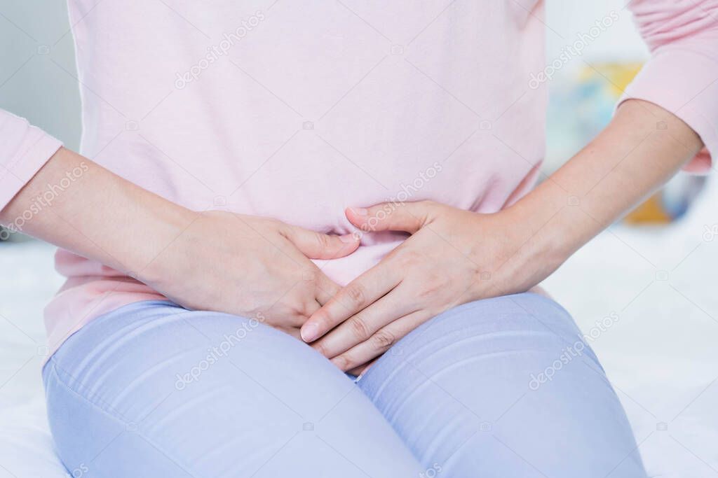 Gynecology concept. Hands of young woman on stomach as suffer from menstruation cramp, indigestion, gastrointestinal, diarrheas or female diseases problem