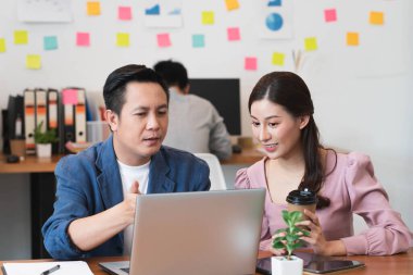 Meslektaşını yeni proje ve çalışma planlaması için eğiten kıdemli erkek yönetici, yeni stajyere iş yerinde yeni beceriler, denetleme veya takım çalışması konseptini öğretiyor