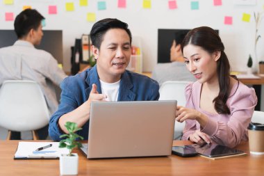 Meslektaşını yeni proje ve çalışma planlaması için eğiten kıdemli erkek yönetici, yeni stajyere iş yerinde yeni beceriler, denetleme veya takım çalışması konseptini öğretiyor