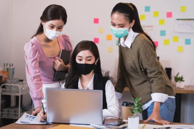 Kovid19 koruma koronası gribi için koruyucu maske takan Asyalı küçük işletme grubu sağlık fikirleri konsepti ofisinin arka planını engelliyor..