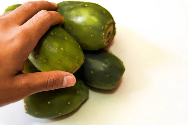 Beyaz arka planda dikenli bir armut alan erkek.