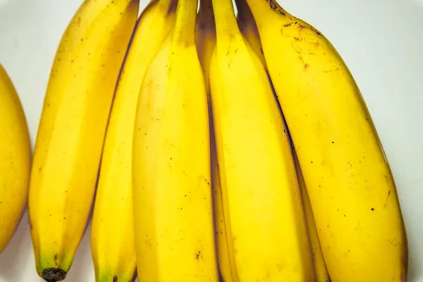 Beyaz arkaplanda istiflenmiş muzlar, görüntüyü kapatın