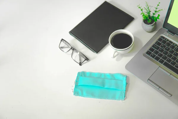 Ofiste yeni normal, kahve, bilgisayar, bardak ve defter