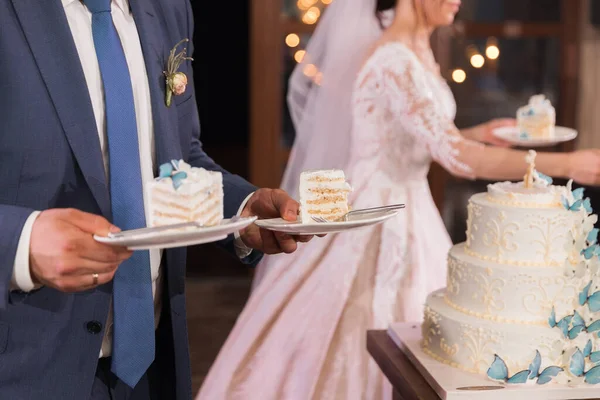 Cut A Piece Of Wedding Cake In The Hands Of The Bride And Groom