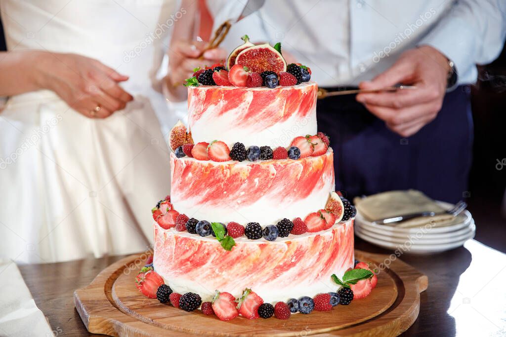 Wedding cake with many different fruits and wild berries and figs on top