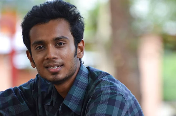 Genç Hintli çocuk kameraya gülümsüyor.