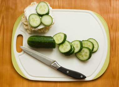 Sağlıklı bir kahvaltı sandviçi hazırlamak için talimatlar. İkinci adım salatalıkları krem peynirin üzerine koy. Sağlıklı kahvaltı, organik krem peynirli çıtır ekmek ve...