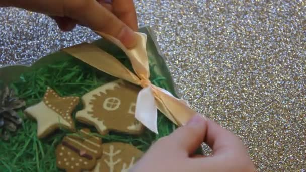 Kadın eli hediye olarak zencefilli kurabiye kutusuna fiyonk bağlar. Noel hediyesi — Stok video