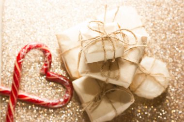 Noel hediyesi olarak İskandinav usulü paketleniyor. Minimalist ve çevre dostu hediye paketi. Kalp şeklinde Noel şekeri kamışı.