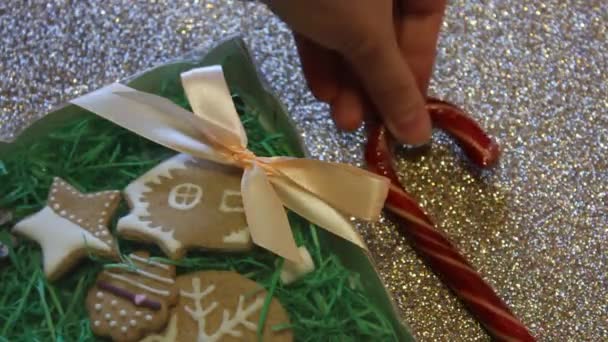 Las manos femeninas atan el lazo de regalo en una caja de regalo de galletas de jengibre. Regalo de Navidad — Vídeos de Stock