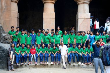 MUMBAI, MAHARASHTRA, INDIA, 9 Aralık 2024: UNESCO Dünya Mirası Sitesi, Fil Mağaraları 'nın mimarisi ve heykeline bakan turist.